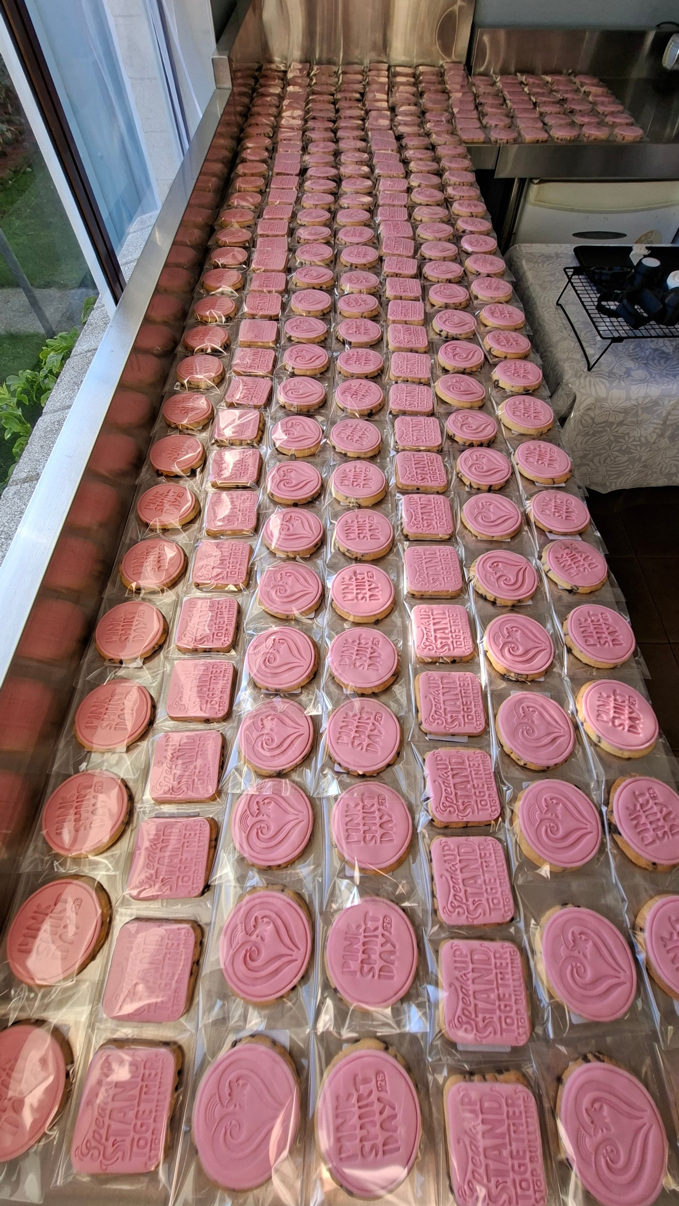 Pink Shirt Day cookies on production bench overhead